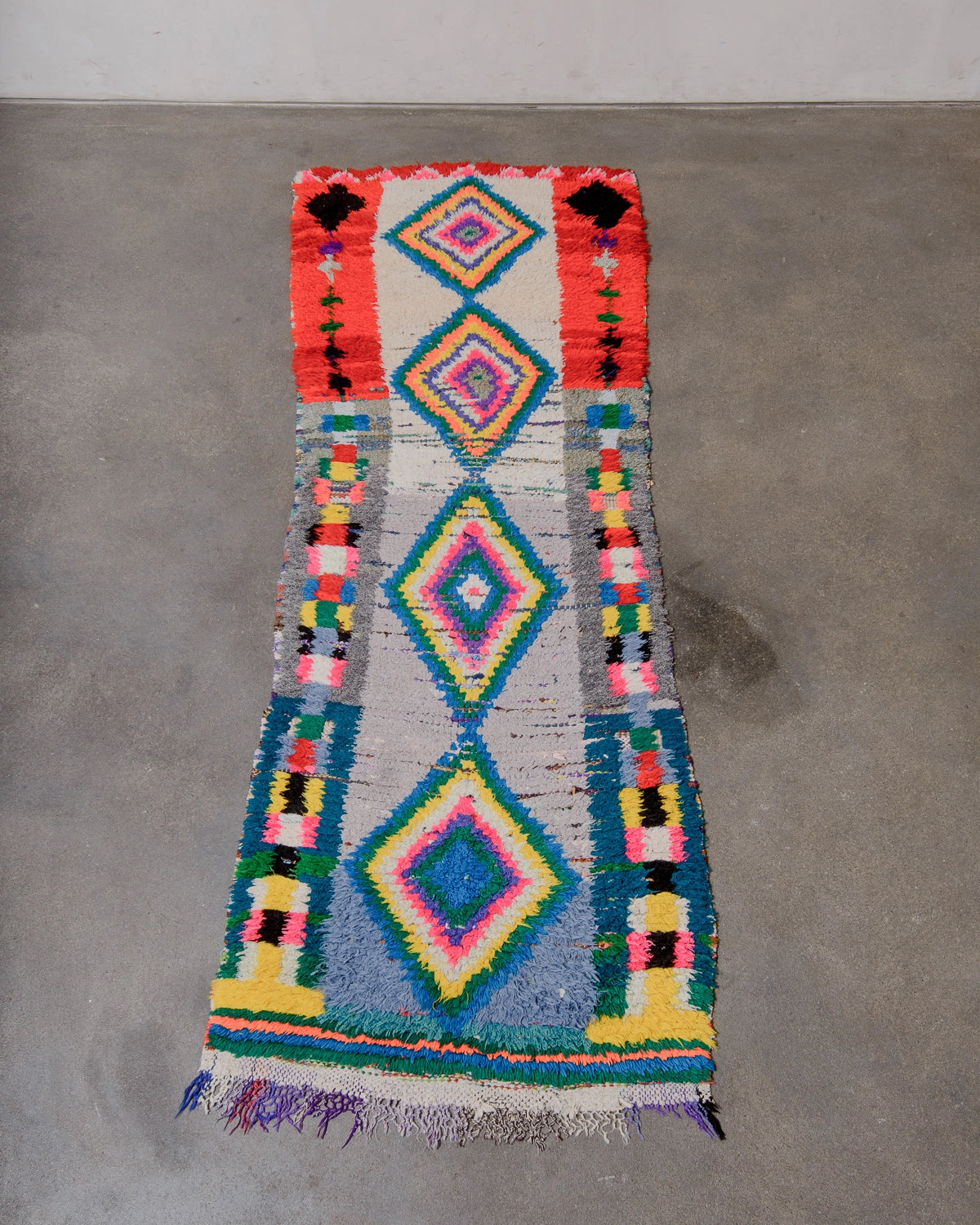 Berberlin Vintage Berber Rug in shades of red, cream, grey and blue with coloured diamond motifs in the center.